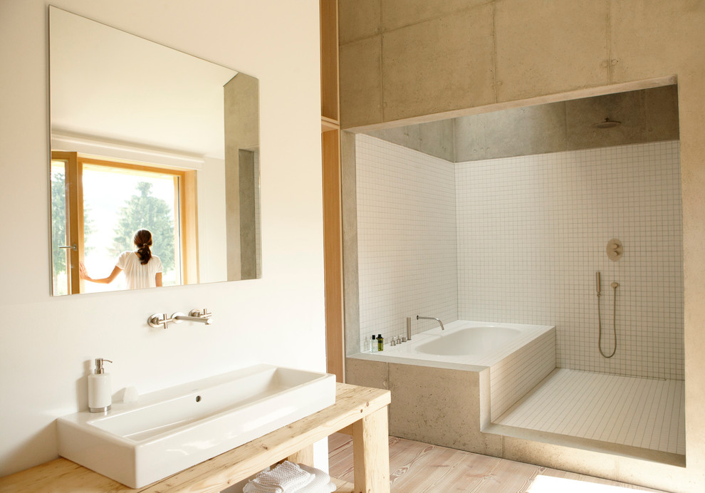 На фото: большая ванная комната в современном стиле с открытыми фасадами, накладной ванной, открытым душем, белой плиткой, керамической плиткой, белыми стенами, светлым паркетным полом, настольной раковиной, столешницей из дерева, открытым душем и бежевой столешницей