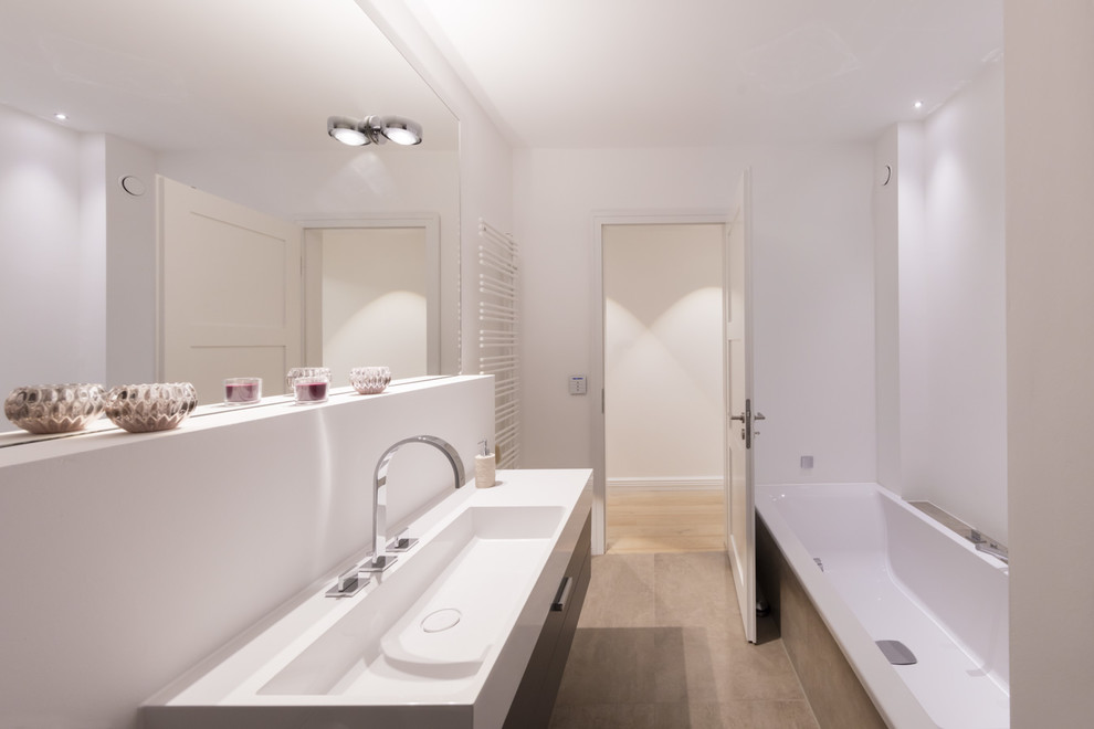 Foto di una piccola stanza da bagno con doccia minimal con ante lisce, vasca da incasso, pareti bianche, lavabo integrato e pavimento beige