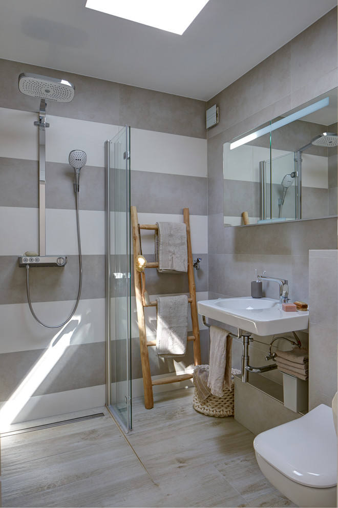 Inredning av ett skandinaviskt litet badrum, med en kantlös dusch, beige kakel, stenkakel och med dusch som är öppen