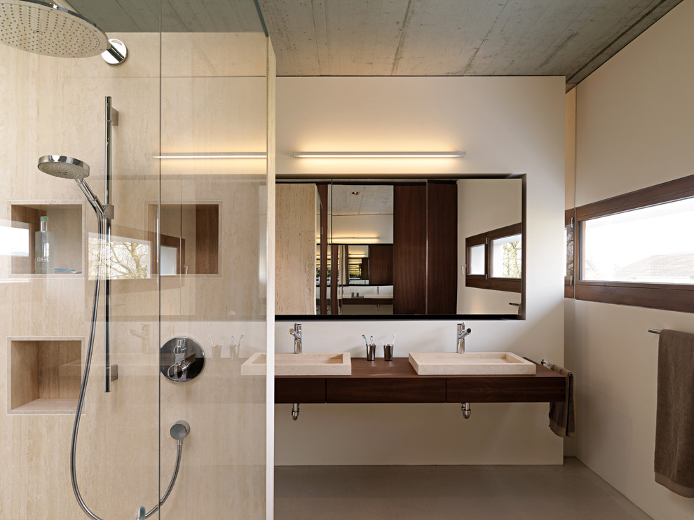 Стильный дизайн: ванная комната среднего размера в современном стиле с душем без бортиков, бежевой плиткой, плиткой из листового камня, белыми стенами, бетонным полом, настольной раковиной и столешницей из дерева - последний тренд