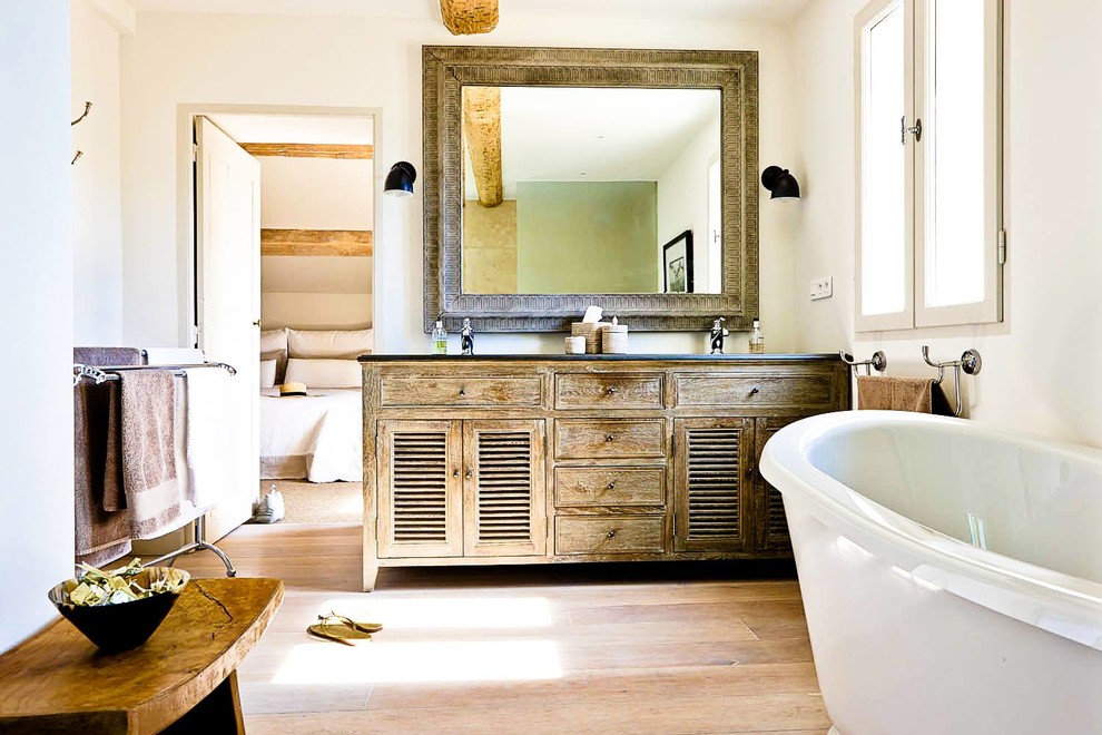 Exempel på ett mellanstort shabby chic-inspirerat en-suite badrum, med luckor med lamellpanel, skåp i slitet trä, ett fristående badkar, vita väggar och mellanmörkt trägolv