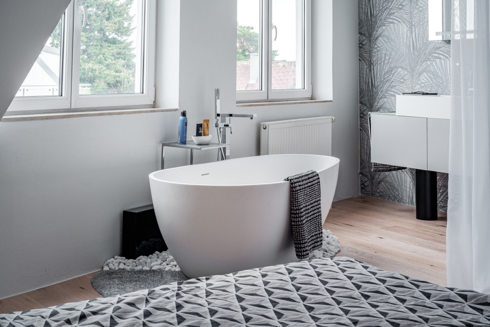 Idéer för ett mellanstort modernt vit en-suite badrum, med släta luckor, grå skåp, ett fristående badkar, en toalettstol med separat cisternkåpa, linoleumgolv, ett fristående handfat, bänkskiva i akrylsten och grått golv
