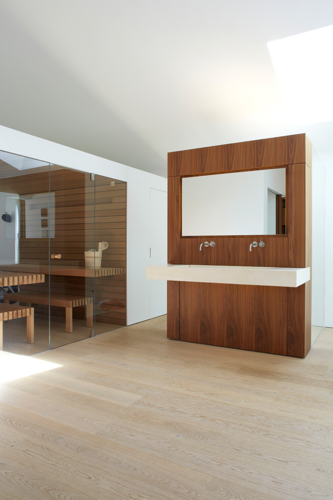 Modelo de sauna minimalista extra grande con paredes blancas, suelo de madera clara y lavabo de seno grande