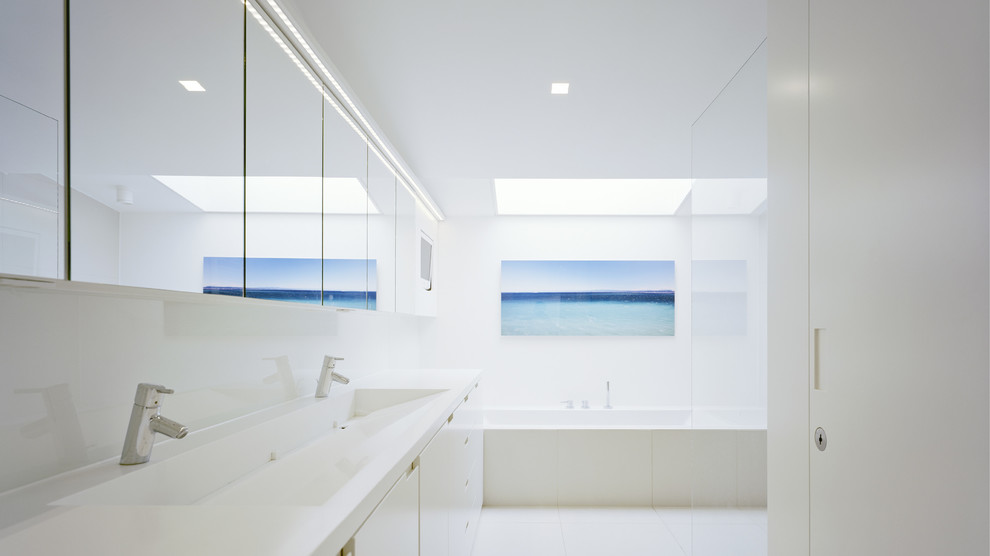 Inspiration för ett stort funkis badrum, med ett avlångt handfat, släta luckor, vita skåp, ett badkar i en alkov, vit kakel, vita väggar och keramikplattor