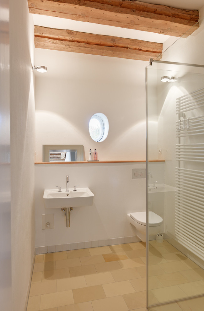 Modelo de cuarto de baño contemporáneo pequeño con lavabo suspendido, sanitario de pared, paredes blancas y ducha a ras de suelo