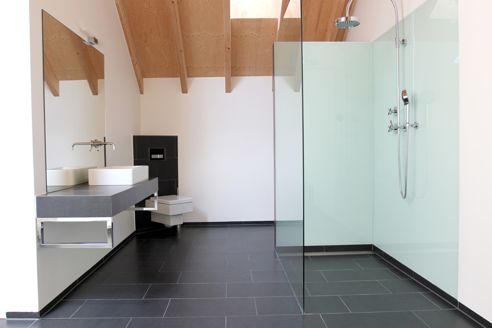 Идея дизайна: ванная комната среднего размера в современном стиле с настольной раковиной, душем без бортиков, инсталляцией, белыми стенами, душевой кабиной, плиткой из листового стекла и полом из сланца