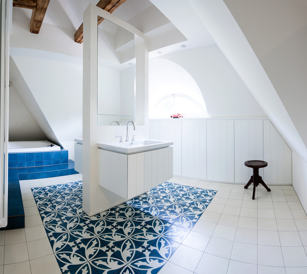 Großes Modernes Badezimmer mit flächenbündigen Schrankfronten, weißen Schränken, Badewanne in Nische, blauen Fliesen, Keramikfliesen, weißer Wandfarbe, Keramikboden und Einbauwaschbecken in Frankfurt am Main
