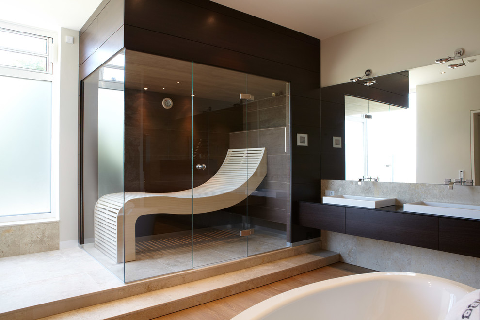 Inspiration pour un grand sauna design en bois foncé avec une baignoire indépendante, un mur blanc, un sol en bois brun, une vasque, un placard à porte plane, un carrelage de pierre et un plan de toilette en bois.