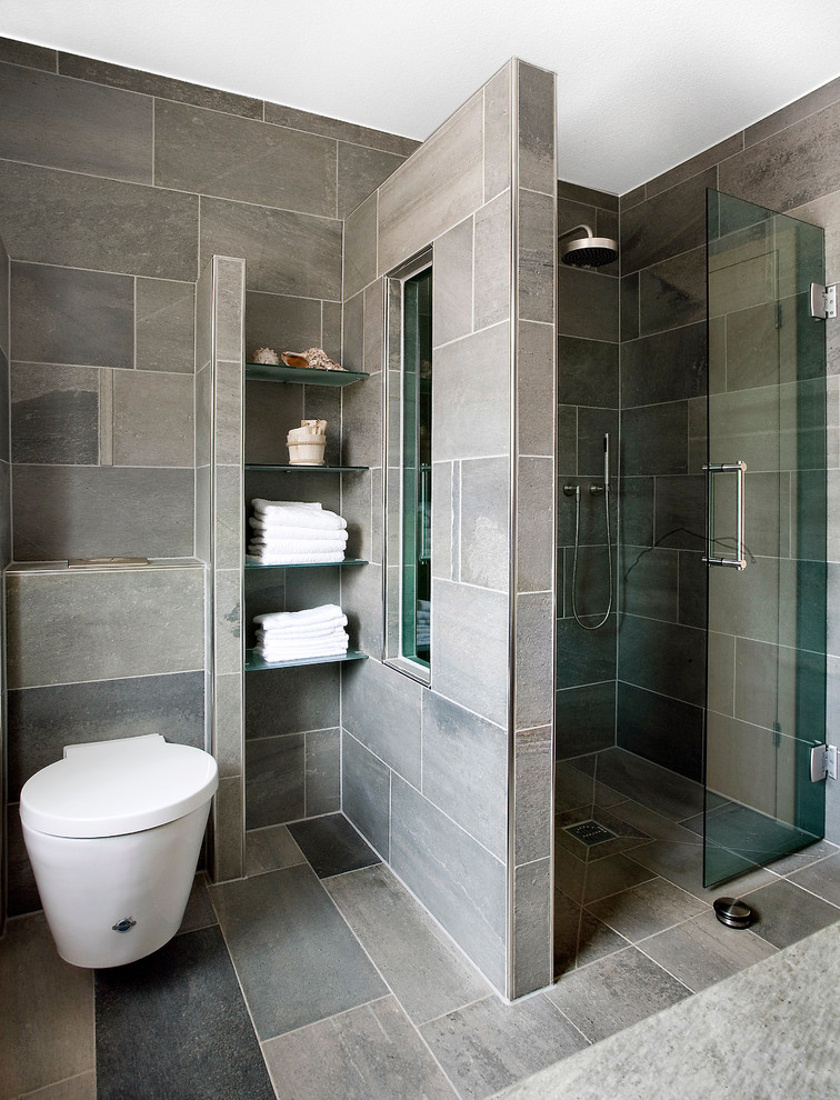 Bild på ett mellanstort funkis badrum med dusch, med en dusch i en alkov, en vägghängd toalettstol, grå kakel, stenhäll och skiffergolv