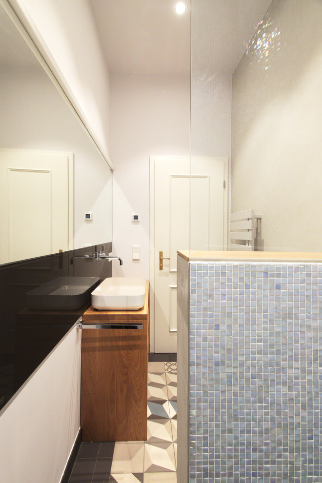 Inspiration för små moderna badrum med dusch, med öppna hyllor, skåp i ljust trä, blå kakel, mosaik, träbänkskiva, en öppen dusch, en vägghängd toalettstol och ett fristående handfat