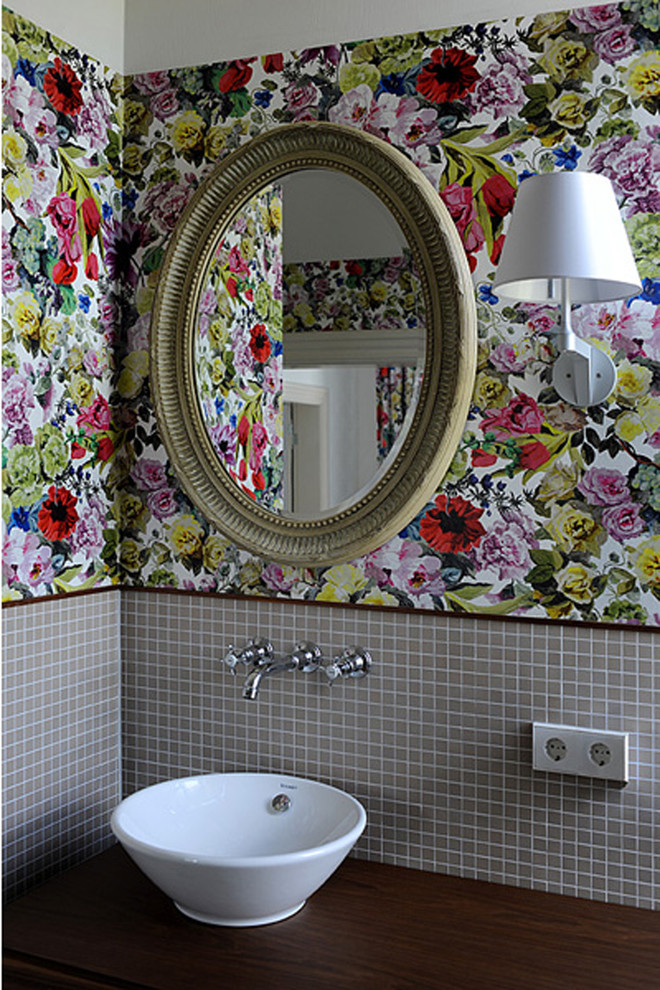 Ejemplo de cuarto de baño tradicional con baldosas y/o azulejos grises, baldosas y/o azulejos en mosaico, paredes multicolor, lavabo sobreencimera y encimera de madera