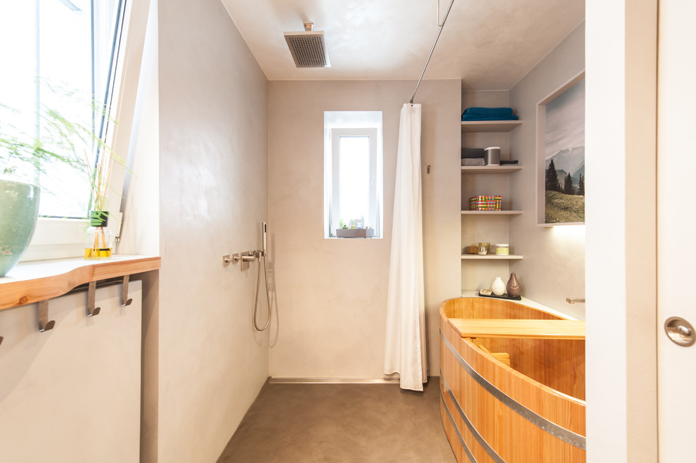 Idee per una stanza da bagno padronale design di medie dimensioni con vasca giapponese, zona vasca/doccia separata, pareti grigie, nessun'anta, pavimento in cemento, pavimento grigio e doccia con tenda