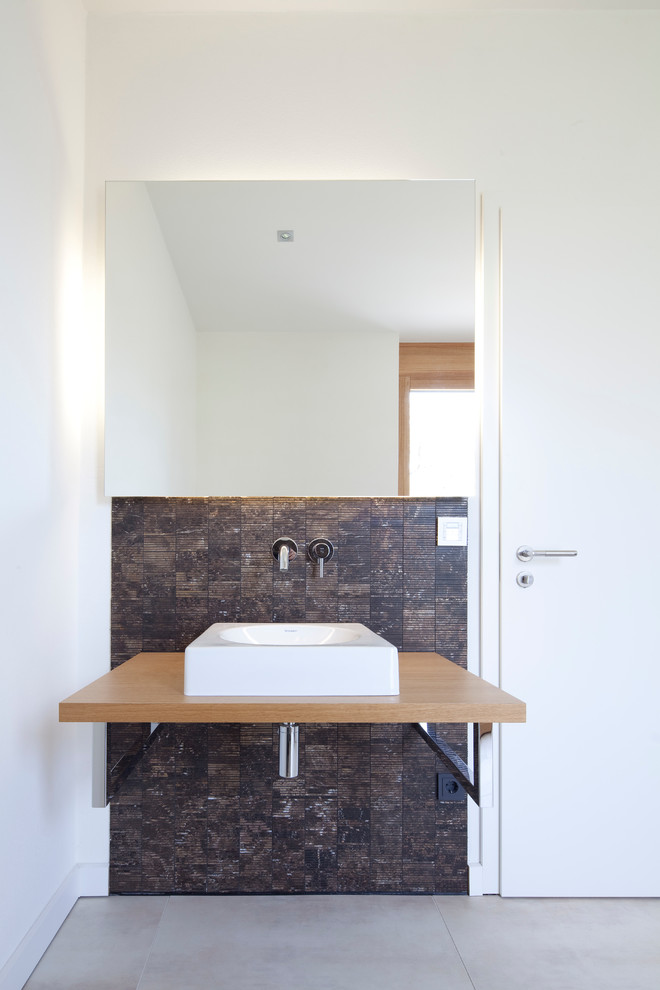 Idéer för eklektiska badrum, med ett fristående handfat, träbänkskiva, brun kakel och vita väggar