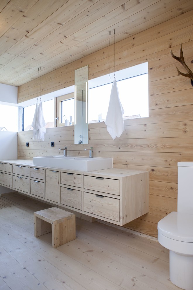 Cette image montre une salle d'eau rustique en bois clair avec parquet clair et un plan de toilette en bois.