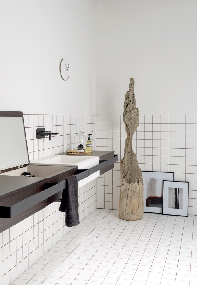 Cette photo montre une salle de bain moderne avec un lavabo suspendu et un mur blanc.
