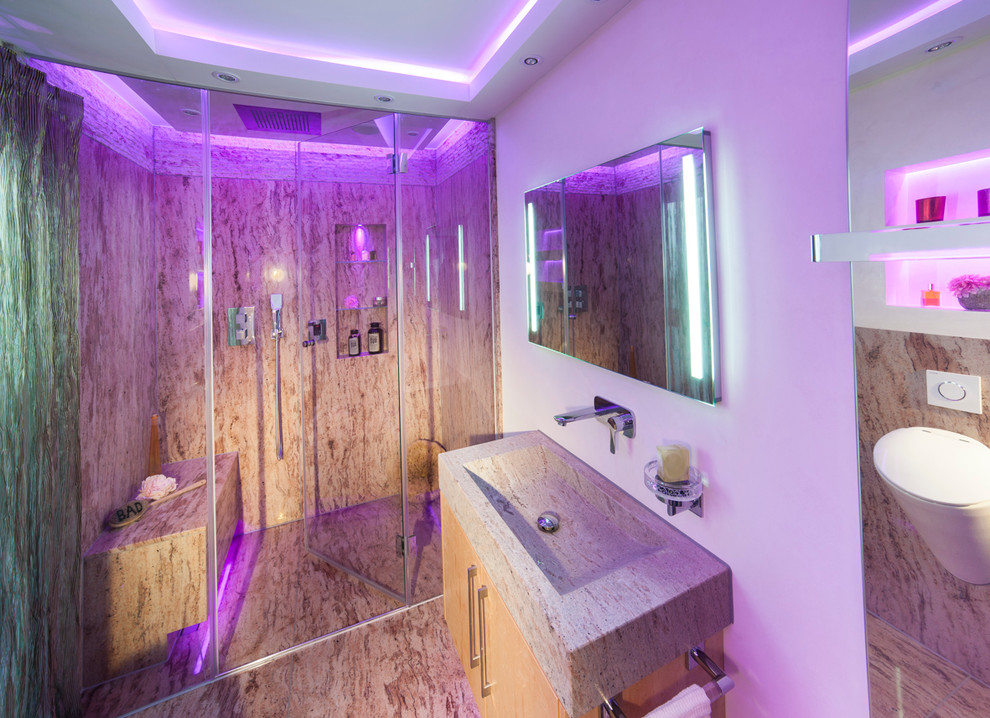 Modern inredning av ett mellanstort en-suite badrum, med släta luckor, gula skåp, en kantlös dusch, en vägghängd toalettstol, flerfärgad kakel, stenhäll, vita väggar, ett fristående handfat och granitbänkskiva