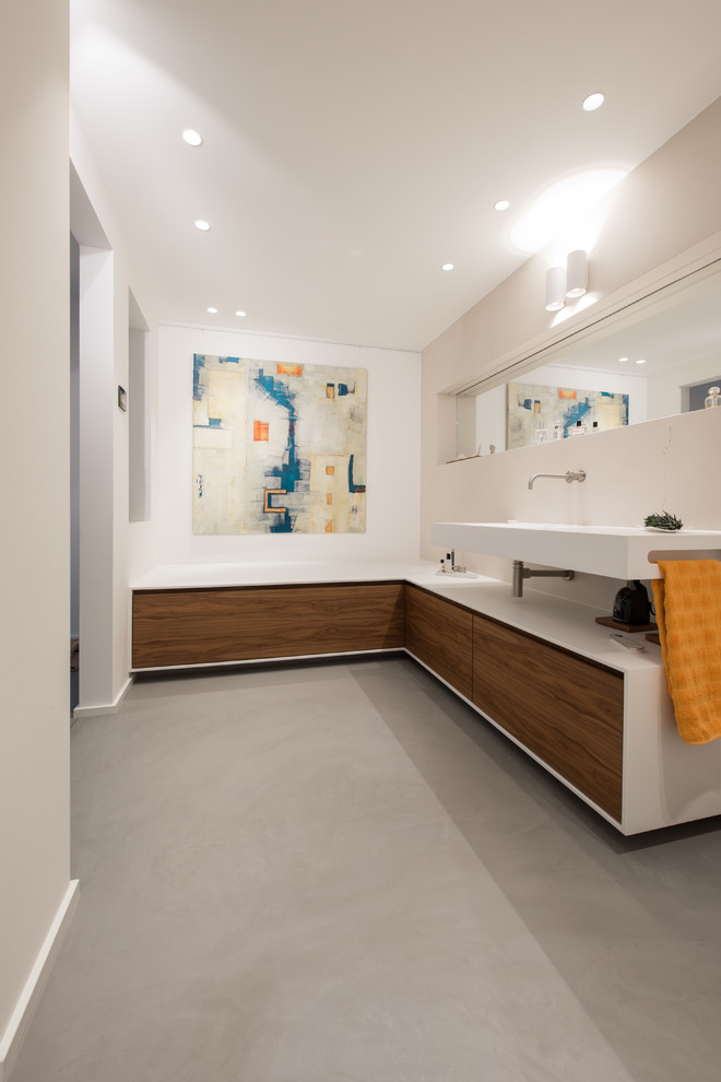 Example of a large trendy 3/4 concrete floor and gray floor drop-in bathtub design in Cologne with flat-panel cabinets, brown cabinets, white walls, a wall-mount sink, wood countertops and white countertops