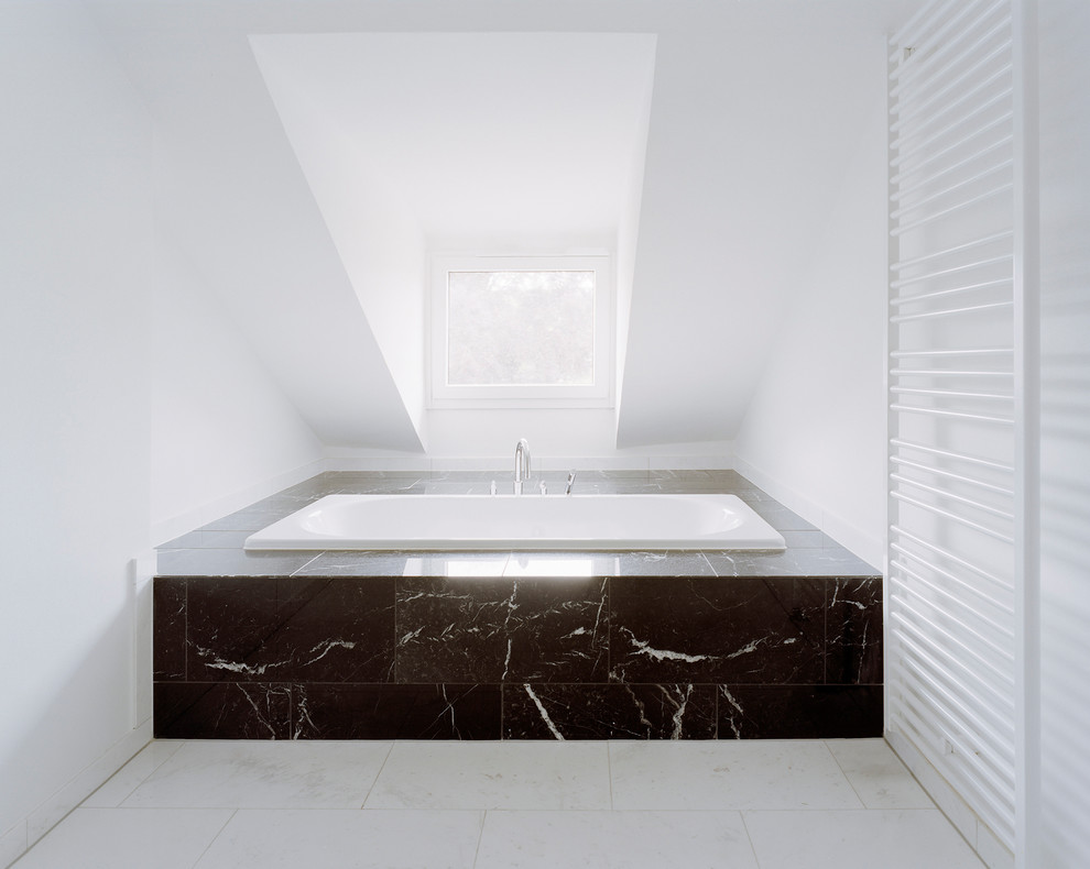На фото: ванная комната среднего размера в современном стиле с накладной ванной, черной плиткой, каменной плиткой, белыми стенами и мраморным полом с