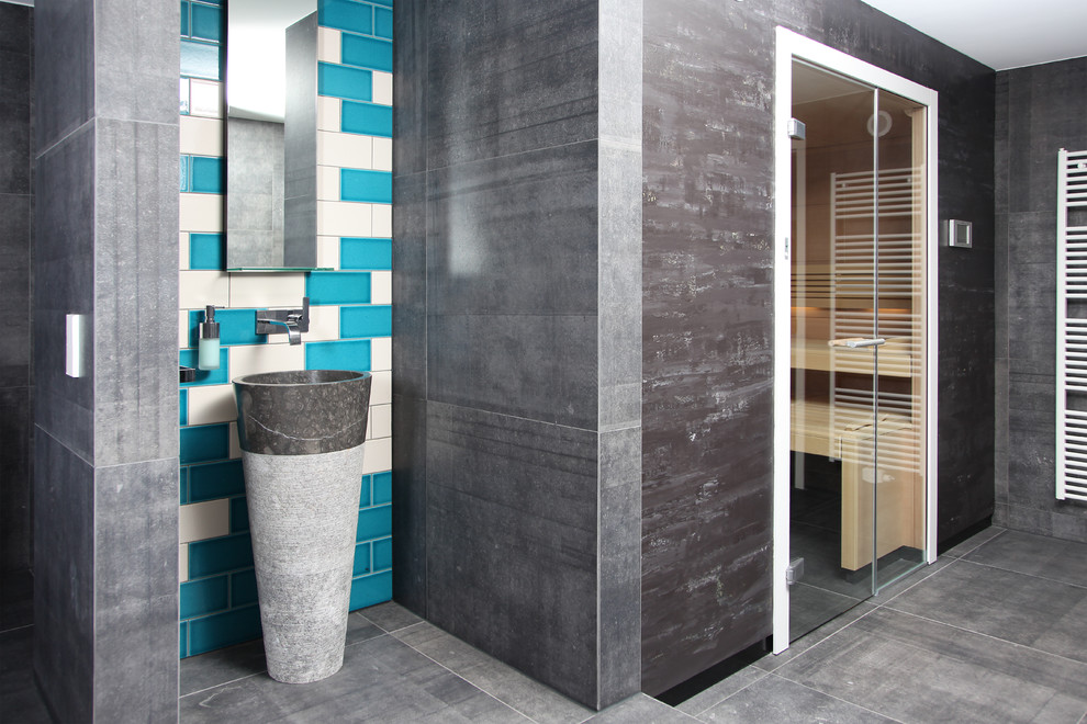 Immagine di una sauna minimal con lastra di pietra, pavimento in cemento e lavabo a colonna