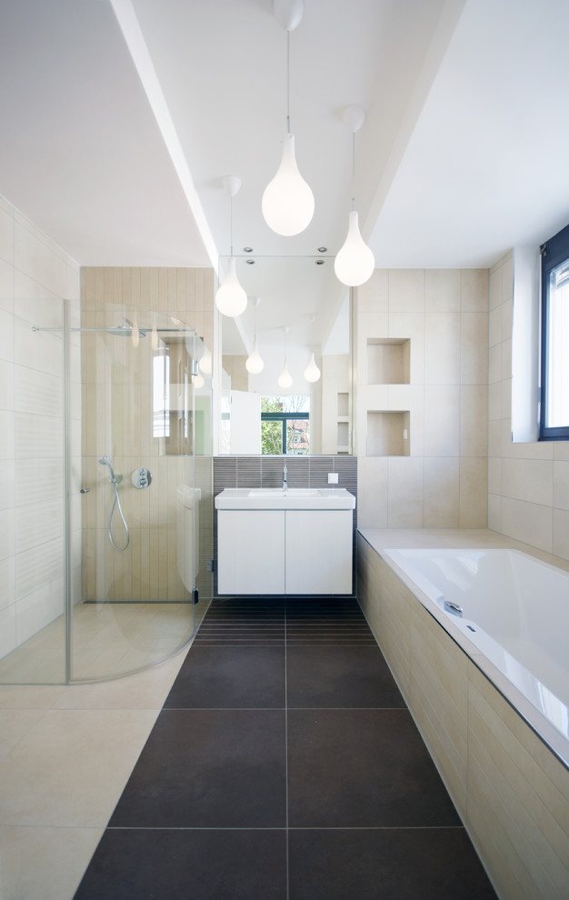 Cette photo montre une grande salle de bain principale tendance avec un lavabo intégré, un placard à porte plane, des portes de placard blanches, une baignoire posée, une douche d'angle, un carrelage beige et un mur beige.