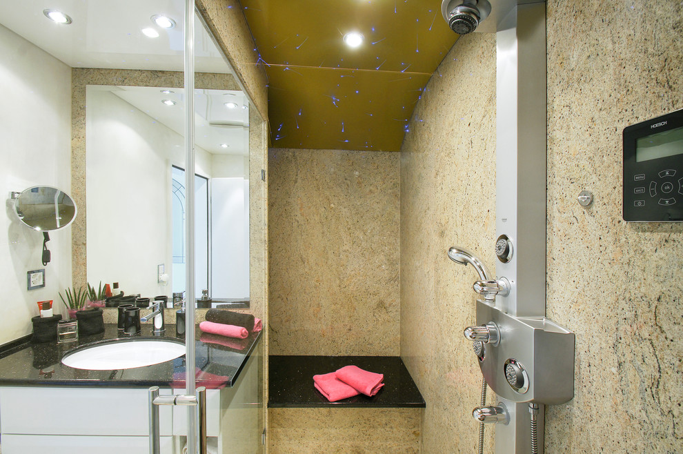 На фото: ванная комната в современном стиле с душем без бортиков, бежевыми стенами, раковиной с несколькими смесителями и столешницей из гранита с
