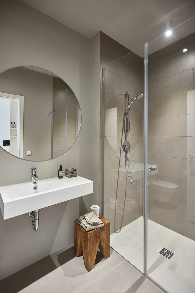 Inspiration för små moderna badrum med dusch, med en kantlös dusch, brun kakel, cementkakel, bruna väggar, cementgolv, ett väggmonterat handfat, bänkskiva i akrylsten, beiget golv och dusch med skjutdörr