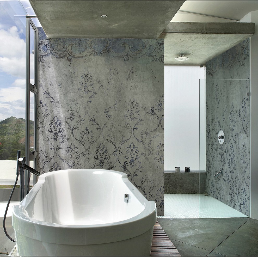 Exemple d'une petite salle de bain principale tendance avec un placard à porte plane, des portes de placard grises, une baignoire indépendante, une douche à l'italienne, WC suspendus, un carrelage gris, un mur gris, carreaux de ciment au sol, un sol gris et une cabine de douche à porte battante.