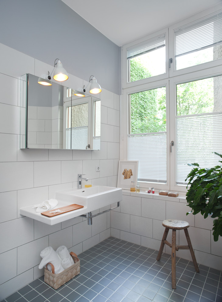 На фото: ванная комната среднего размера в современном стиле с подвесной раковиной, белой плиткой и белыми стенами