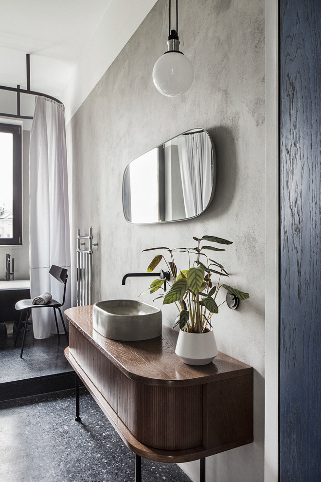 Cette image montre une salle de bain design en bois foncé avec un mur gris, une vasque, un plan de toilette en bois, un sol noir, un plan de toilette marron et un placard à porte plane.