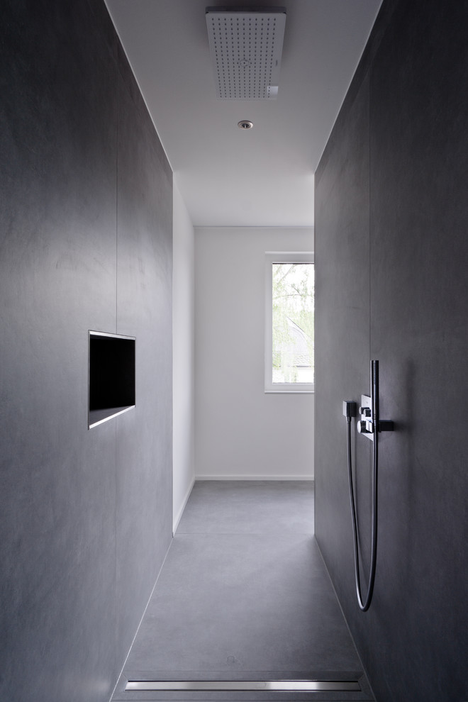 Стильный дизайн: большая ванная комната в стиле модернизм с душем без бортиков, черной плиткой, белыми стенами, полом из цементной плитки, душевой кабиной, черным полом и открытым душем - последний тренд