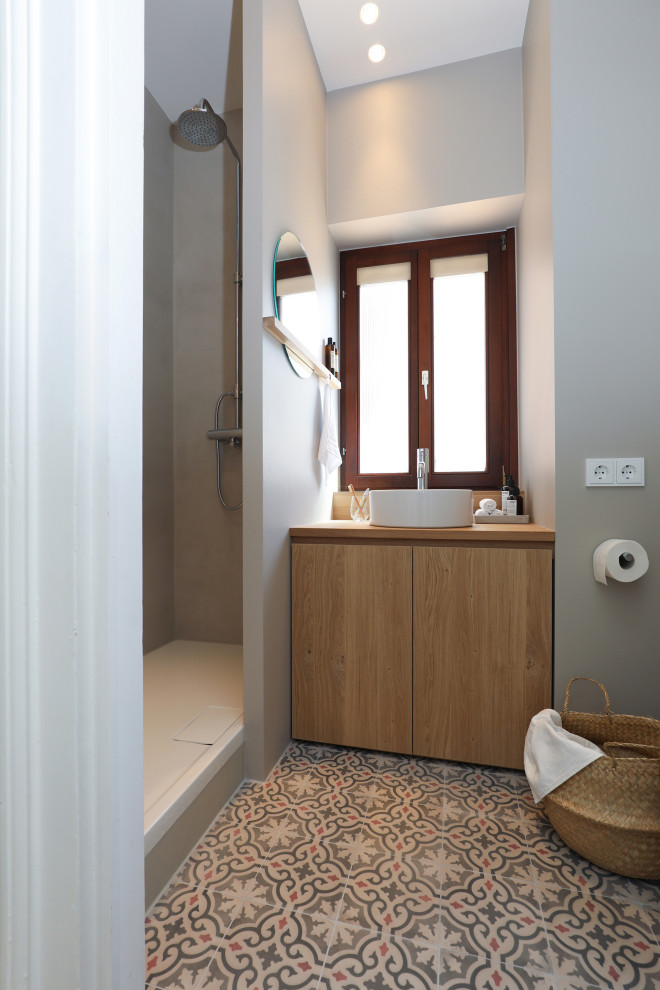 Свежая идея для дизайна: маленькая ванная комната в стиле модернизм с плоскими фасадами, светлыми деревянными фасадами, душем в нише, раздельным унитазом, серой плиткой, серыми стенами, полом из цементной плитки, душевой кабиной, настольной раковиной, столешницей из дерева, разноцветным полом, открытым душем, тумбой под одну раковину, встроенной тумбой, потолком с обоями и обоями на стенах для на участке и в саду - отличное фото интерьера