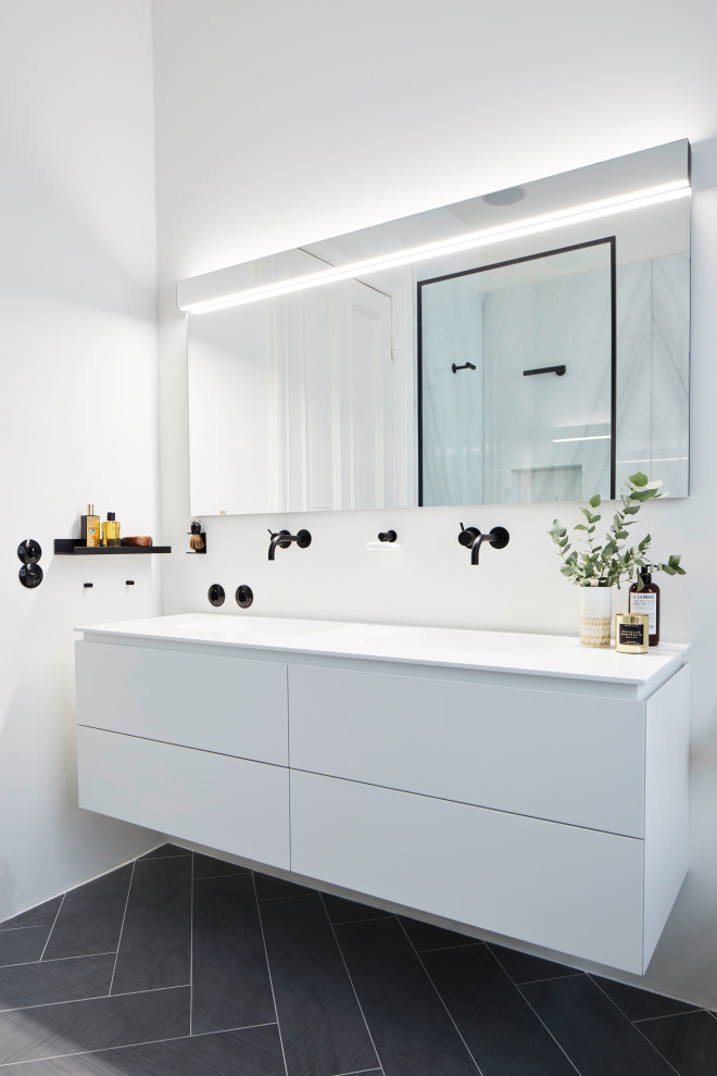 Contemporary bathroom in Hamburg with flat-panel cabinets, white cabinets, white walls, black floors, white worktops, a floating vanity unit and double sinks.
