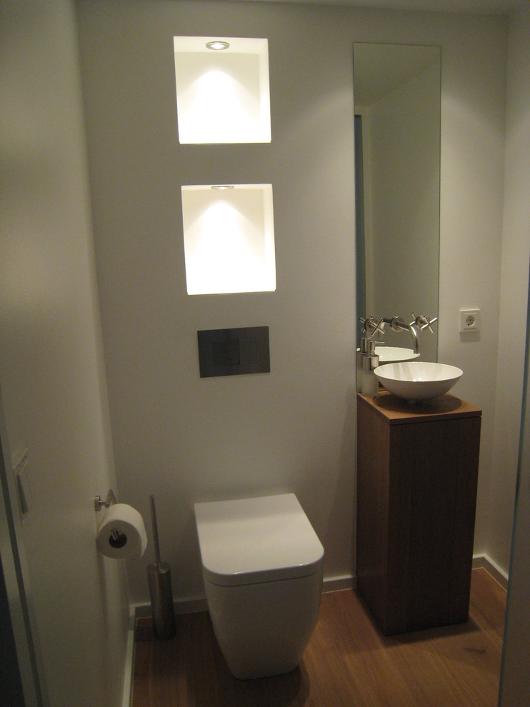 Inspiration för ett litet funkis toalett, med släta luckor, bruna skåp och träbänkskiva