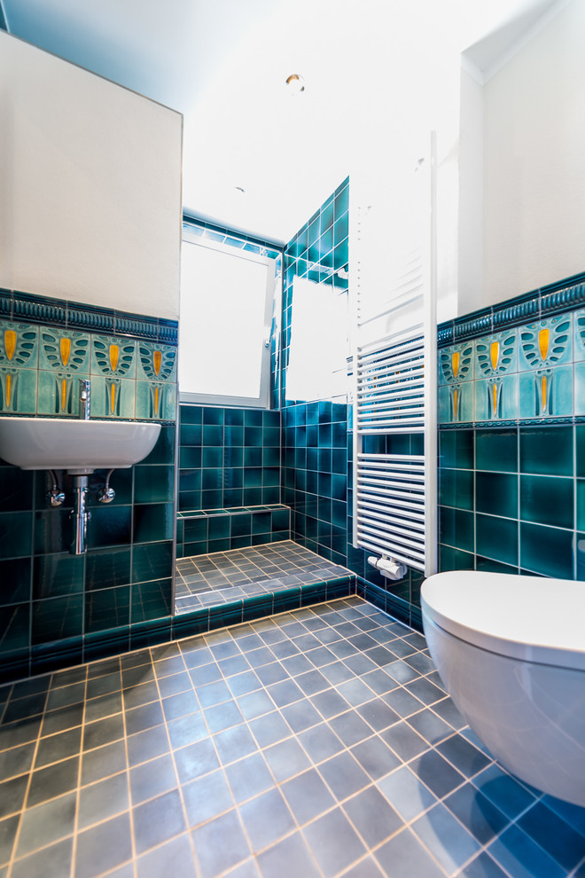 Idee per una stanza da bagno chic di medie dimensioni con WC sospeso, piastrelle multicolore, piastrelle di cemento, pareti bianche, pavimento in cementine, lavabo sospeso, top in superficie solida e pavimento blu