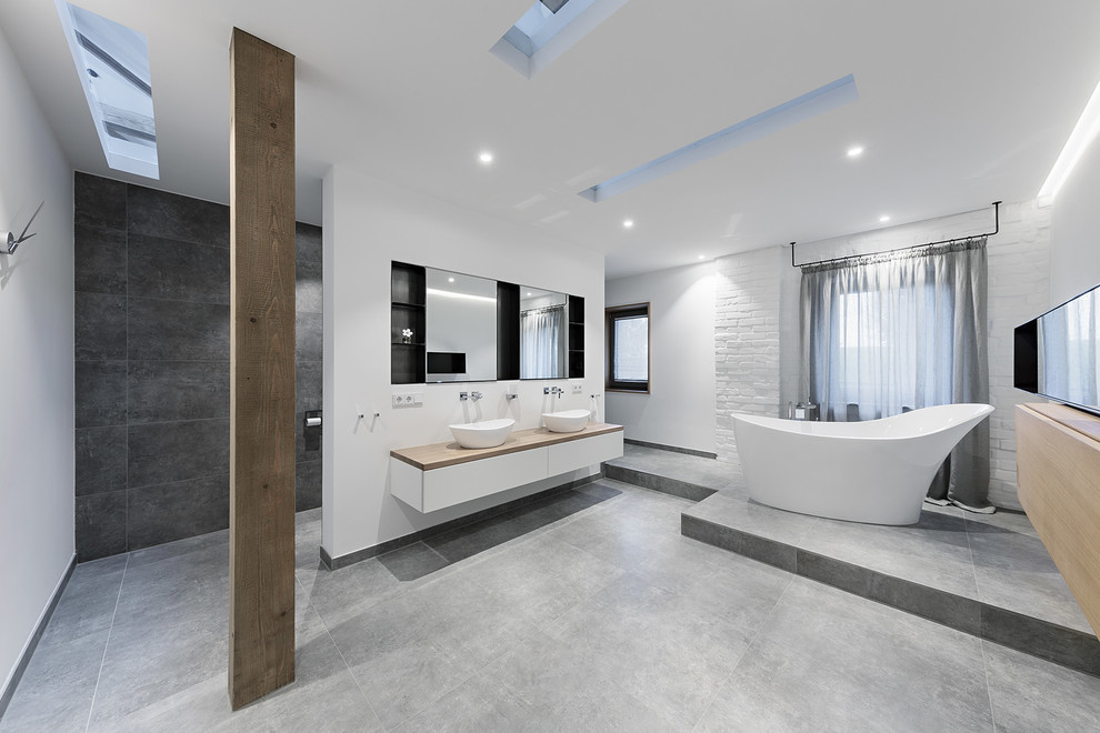 Ispirazione per una stanza da bagno design con piastrelle grigie, pavimento con piastrelle in ceramica e lavabo a bacinella
