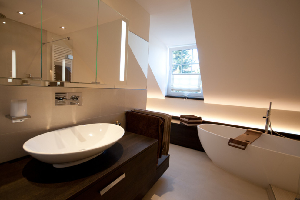 Exempel på ett mellanstort modernt brun brunt en-suite badrum, med ett fristående badkar, skåp i mörkt trä, en öppen dusch, en vägghängd toalettstol, beige kakel, stenkakel, beige väggar, klinkergolv i keramik, ett fristående handfat, beiget golv och med dusch som är öppen