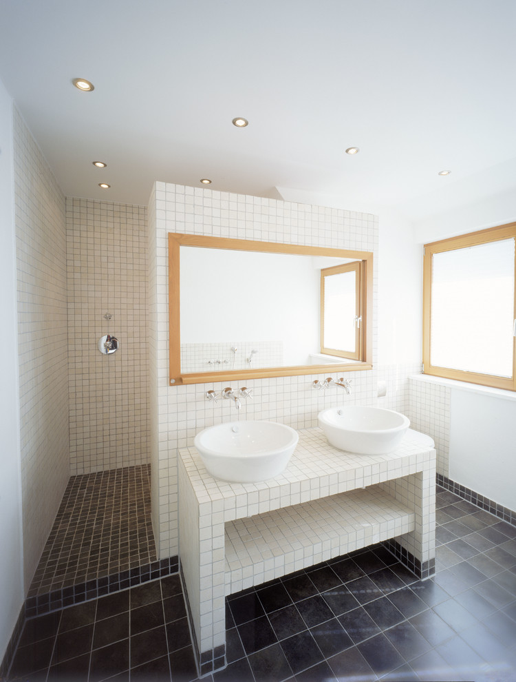 Inredning av ett klassiskt stort badrum, med öppna hyllor, en öppen dusch, beige kakel, vita väggar, skiffergolv, ett fristående handfat, kaklad bänkskiva och med dusch som är öppen
