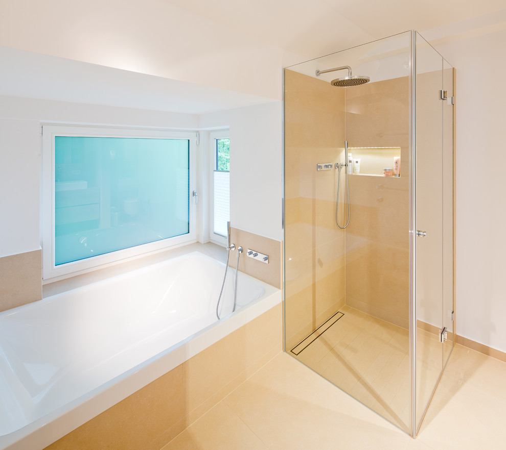 Réalisation d'une salle de bain design avec une baignoire en alcôve, une douche d'angle, un carrelage beige et un mur blanc.