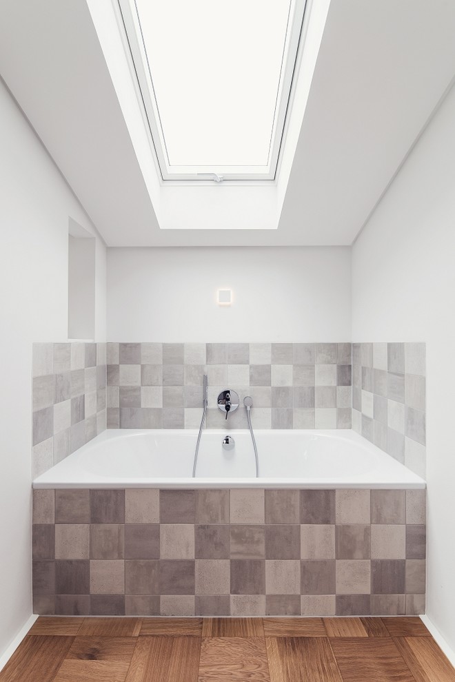 На фото: ванная комната среднего размера в стиле модернизм с плоскими фасадами, белыми фасадами, душем без бортиков, раздельным унитазом, серой плиткой, керамической плиткой, белыми стенами, полом из керамической плитки, настольной раковиной и столешницей из плитки с