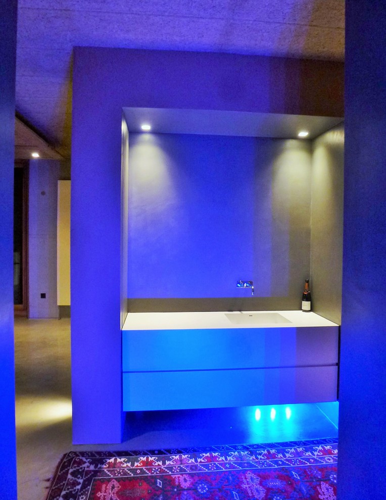 Стильный дизайн: огромная ванная комната в современном стиле с плоскими фасадами, белыми фасадами, отдельно стоящей ванной, душем без бортиков, цементной плиткой, бежевыми стенами, бетонным полом, раковиной с несколькими смесителями и столешницей из искусственного камня - последний тренд
