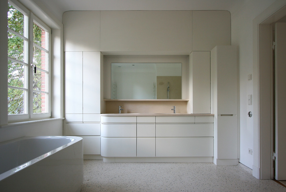 Idées déco pour une salle de bain contemporaine de taille moyenne avec un placard à porte plane, des portes de placard blanches et un mur blanc.