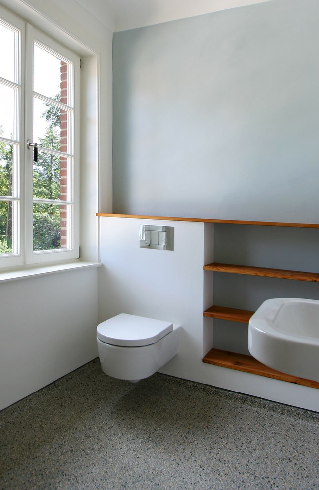 Cette photo montre une salle de bain tendance avec WC suspendus et un mur gris.