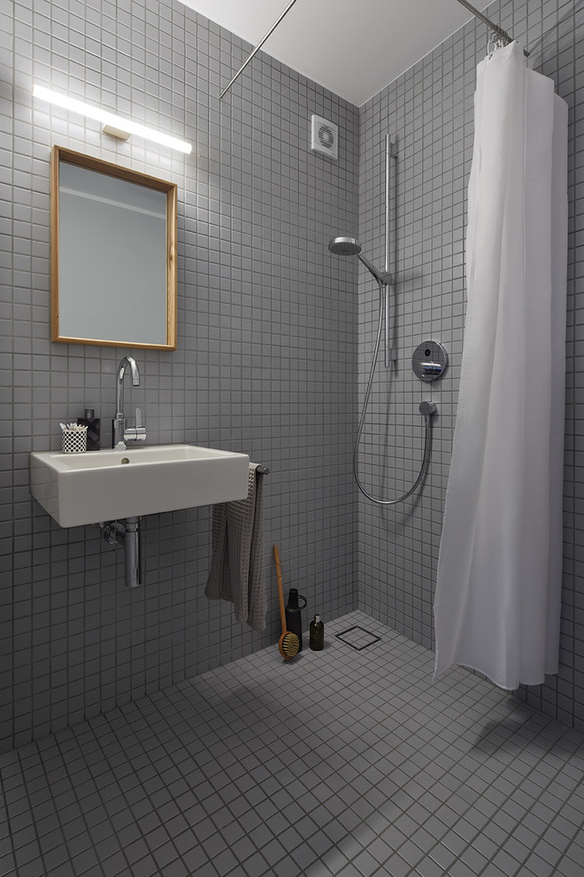 Idéer för små funkis badrum med dusch, med en kantlös dusch, grå kakel, keramikplattor, grå väggar, klinkergolv i keramik, ett väggmonterat handfat och dusch med duschdraperi