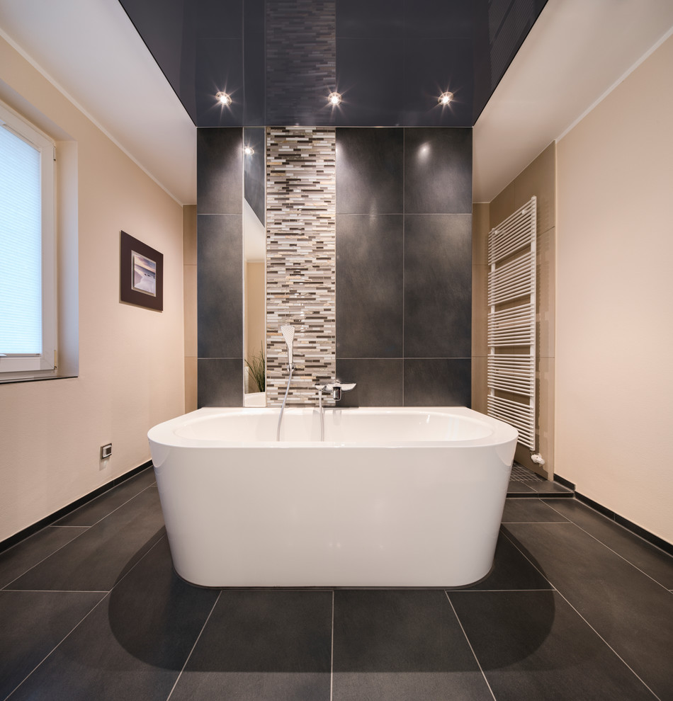Идея дизайна: главная ванная комната среднего размера в современном стиле с отдельно стоящей ванной, бежевой плиткой, серой плиткой, черной плиткой, бежевыми стенами и черным полом