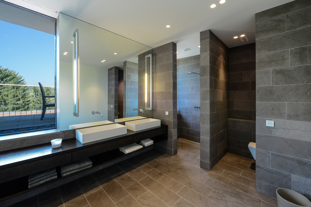 Источник вдохновения для домашнего уюта: главная ванная комната в современном стиле с открытыми фасадами, черными фасадами, открытым душем, серыми стенами, настольной раковиной, открытым душем и зеркалом с подсветкой