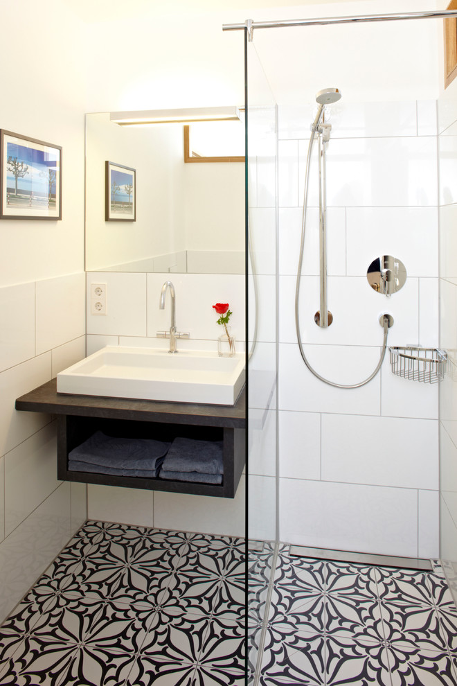 Small elegant 3/4 white tile and ceramic tile ceramic tile and multicolored floor corner shower photo in Munich with a vessel sink, white walls, open cabinets, black cabinets and quartz countertops