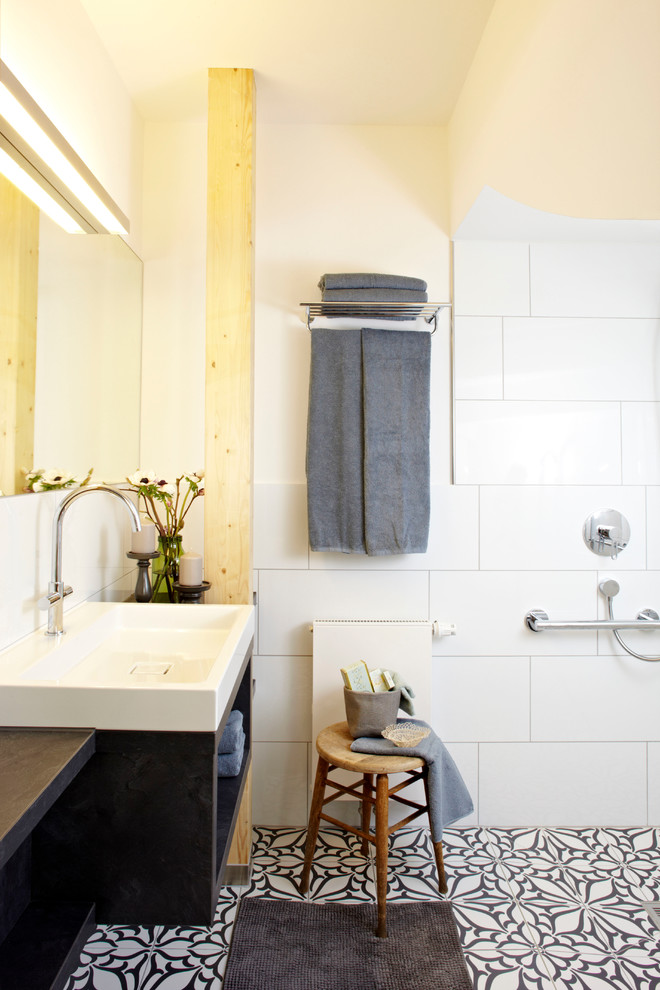 Inspiration för ett mellanstort funkis en-suite badrum, med öppna hyllor, svarta skåp, vit kakel, keramikplattor, beige väggar, klinkergolv i keramik, ett fristående handfat och träbänkskiva