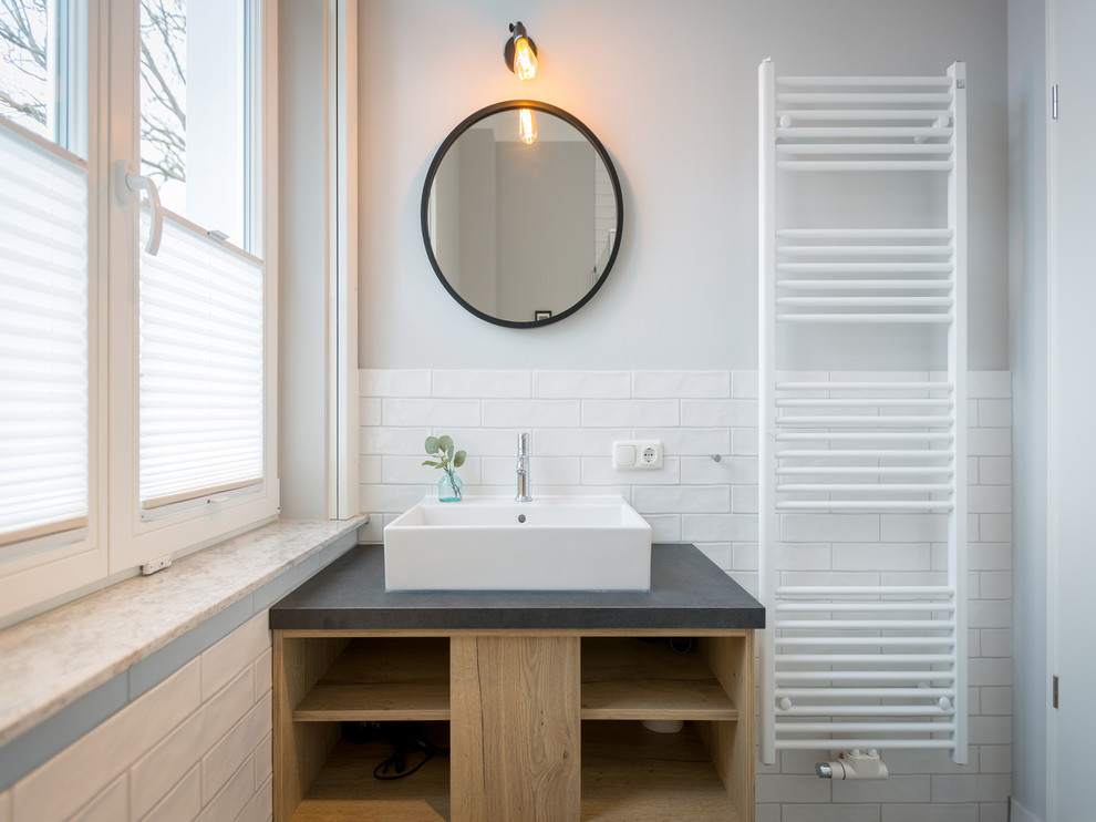 Foto de cuarto de baño contemporáneo pequeño con baldosas y/o azulejos blancos, paredes grises, lavabo sobreencimera, armarios abiertos, baldosas y/o azulejos de cemento, puertas de armario de madera clara y encimeras grises