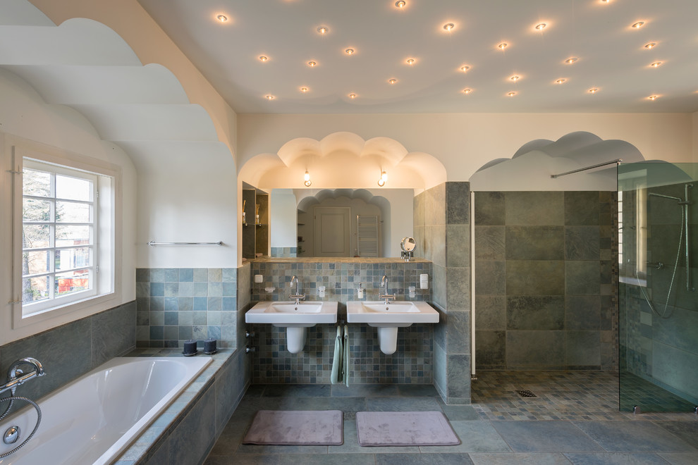 На фото: большая главная ванная комната в классическом стиле с подвесной раковиной, накладной ванной, синей плиткой, каменной плиткой, белыми стенами, полом из сланца, душем в нише и окном с