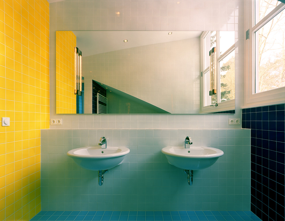 На фото: ванная комната в современном стиле с подвесной раковиной, разноцветными стенами и желтой плиткой